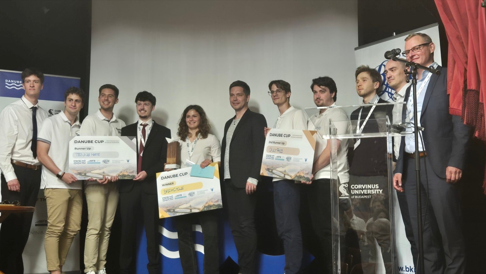 Student teams with their award boards on stage at the Danube Cup 2025 final at Corvinus University in Budapest