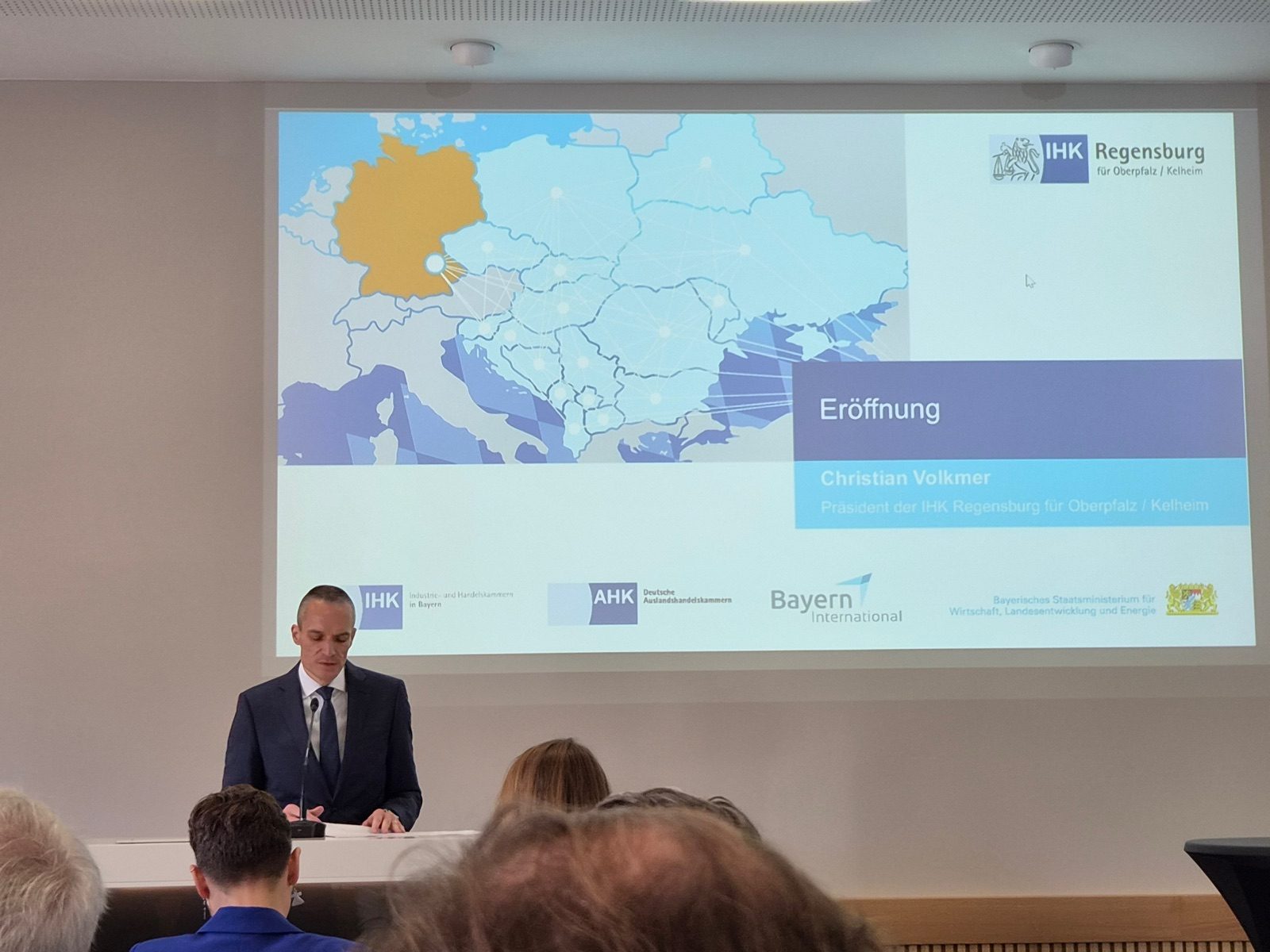 Christian Volkmer at the lectern in front of the opening slide, a map of Germany and Central and Eastern Europe
